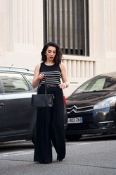 a lady in a black striped tank top and a pair of black wide leg pants